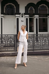 a lady in a white vest and a pair of white pants